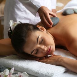 Young woman on massage table in beauty spa salon